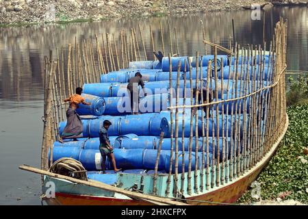 DHAKA, BANGLADESH,MARCH,11,2022-Workers take used drums for recycling at a warehouse in Dhaka. Stock Photo