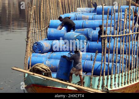 DHAKA, BANGLADESH,MARCH,11,2022-Workers take used drums for recycling at a warehouse in Dhaka. Stock Photo