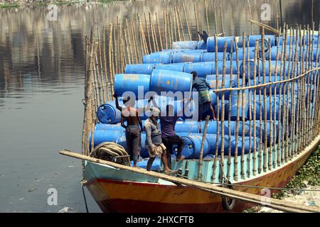 DHAKA, BANGLADESH,MARCH,11,2022-Workers take used drums for recycling at a warehouse in Dhaka. Stock Photo