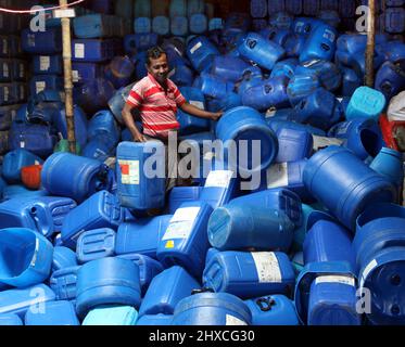 DHAKA, BANGLADESH,MARCH,11,2022-Workers take used drums for recycling at a warehouse in Dhaka. Stock Photo