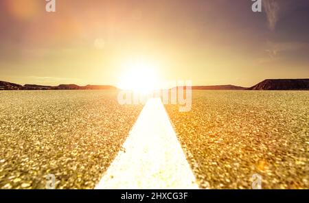 Wide asphalt road to horizon in sunlight Stock Photo