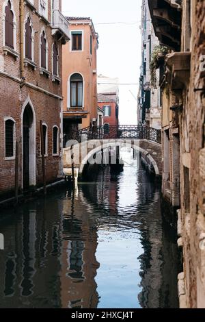 Single gondola traveling on a small canal in Venice, Italy Stock Photo