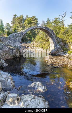 The remains of the Old Packhorse Bridge built in 1717 over the River Dulnain in the village of Carrbridge, Highland, Scotland UK. Stock Photo