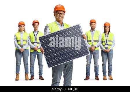 Mature male engineer holding a solar cell panel and other engineers standing in the back isolated on white background Stock Photo
