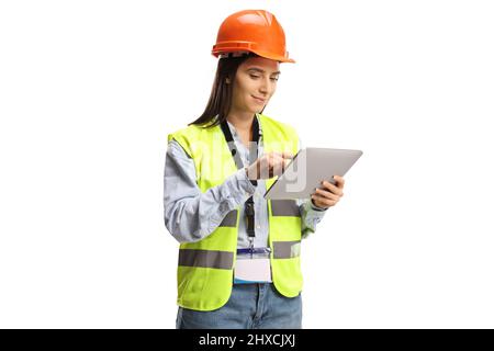 Young female engineer with a safety vest and helmet using a tablet isolated on white background Stock Photo