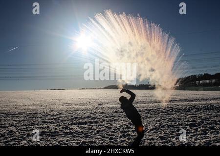 Mpemba effect, boiling water is thrown into the air at sub-zero temperatures Stock Photo