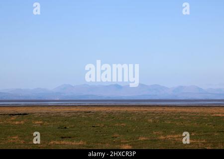 Distant view of the English Lake District hills seen from Pilling Lane Preesall looking across Pilling Sands and the River Lune estuary on a clear day. Stock Photo