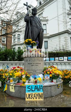 London, UK.  11 March 2022.  The statue of St Volodymyr, ruler of Ukraine 980-1015, is seen near Holland Park surrounded by sunflowers and messages of support for Ukraine. The statue was erected by Ukrainians in Britain to celebrate the establishment of Christianity in Ukraine by St Volodymyr in 988.  Ukraine’s current leader and namesake, President Volodymyr Zelenskyy, is leading Ukraine in its defence against Russia’s invasion. Credit: Stephen Chung / Alamy Live News Stock Photo