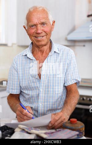 Enthusiastic man making list of repair works Stock Photo