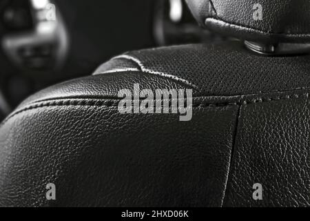 Part of the leather black perforated details of a car seat of a modern car. Stock Photo