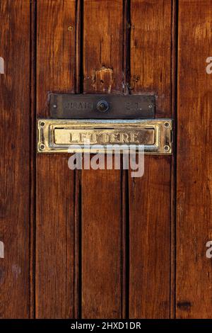 Wooden door with a golden mailbox insert in the old town of Venice, Italy Stock Photo