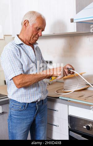 Senior man working on apartment overhauls Stock Photo