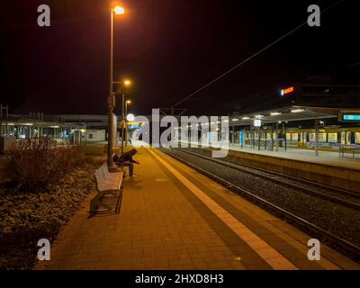 Man sitting alone on the platform in Leinfelden in the early morning Stock Photo