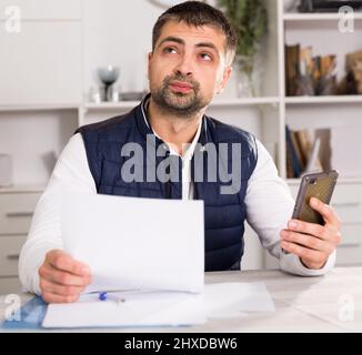 Male business working with documents, holding mobile Stock Photo
