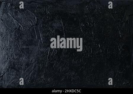 Irregular black plaster texture applied with a spatula on a wal Stock Photo