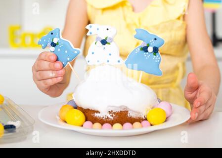 Close-up of an Easter cake decorated with three rabbits and painted eggs. Cooking in the kitchen for a religious holiday . High quality photo Stock Photo