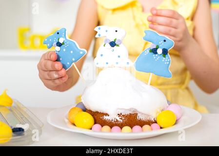 Close-up of an Easter cake decorated with three rabbits and painted eggs. Cooking in the kitchen for a religious holiday . High quality photo Stock Photo