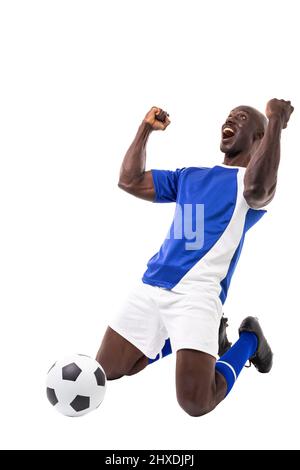 Excited young male african american soccer player celebrating after scoring goal on white background Stock Photo
