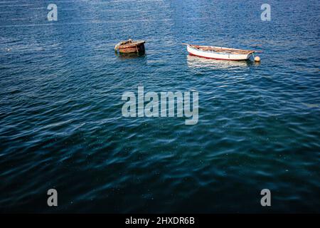 lonely little boat moored to a buoy in the sea Stock Photo