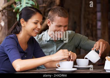 Hmmm.. this looks delicious. Shot of a young couple having coffee at a cafe. Stock Photo