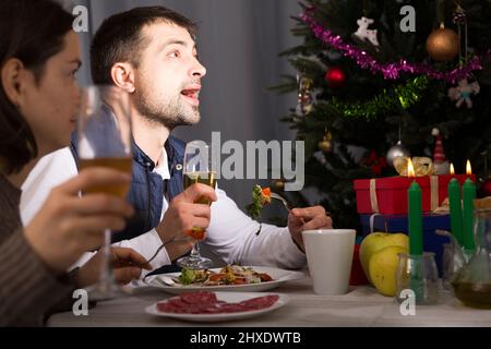 Couple having christmas dinner and watching tv Stock Photo