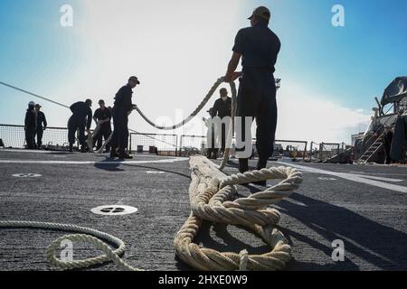 Rota, Spain. 2nd Mar, 2022. Sailors fake-out a mooring line after departing Naval Station Rota while aboard the Arleigh Burke-class guided-missile destroyer USS Porter (DDG 78), Feb. 28, 2022. Porter, forward-deployed to Rota, Spain, is currently underway in the U.S. 6th Fleet area of operations in support of regional allies and partners and U.S. national security interests in Europe and Africa. Credit: U.S. Navy/ZUMA Press Wire Service/ZUMAPRESS.com/Alamy Live News Stock Photo
