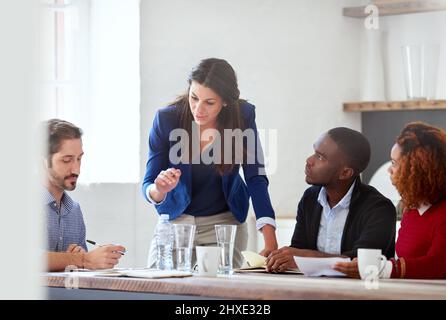 Listen to what Im saying. Cropped shot of a young businesswoman addressing her colleagues during a business meeting. Stock Photo