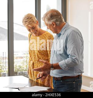Ill go through them with you. Shot of a senior male realtor going through paperwork with a client. Stock Photo