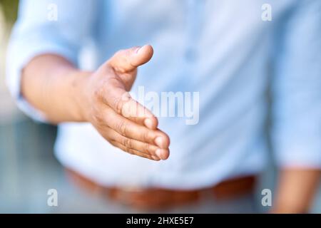 Lets do this, shall we. Cropped shot of an unrecognizable businessman standing with his hand extended for a handshake during the day. Stock Photo