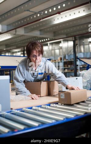Worker packaging a customer's order in a warehouse Stock Photo