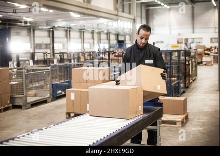 Distribution centre worker sorting packages Stock Photo