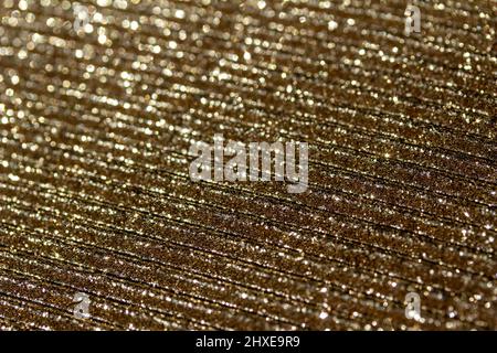 Full frame macro abstract texture of shimmering gold glitter on a corrugated surface background Stock Photo
