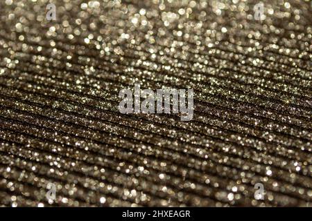 Full frame macro abstract texture of shimmering gold glitter on a corrugated surface background Stock Photo