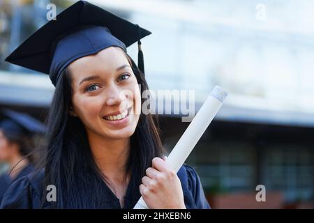 Upwards and onwards. A young college graduate smiling at the camera. Stock Photo