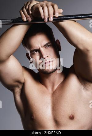 Muscular man hanging on bar and performing calisthenics pull up ...