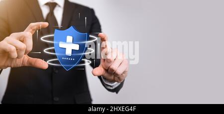 Businessman hold Shield with plus Low polygonal icon, medicine icon.Health shield.Medical logo template,protection symbol with cross sign,healthcare s Stock Photo