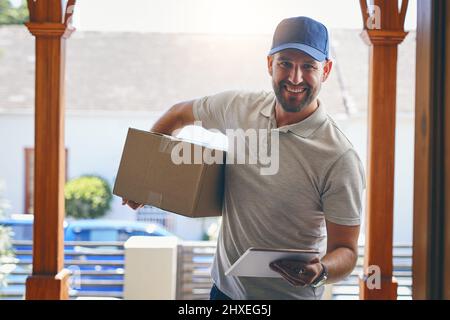 Im here with your speedy delivery. Portrait of a courier making a home delivery. Stock Photo