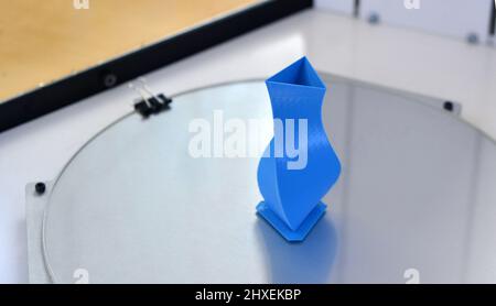Bright blue object printed by 3d printer on 3d printer inside. Stock Photo
