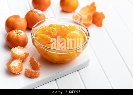 Canned tangerine. Pickled mandarin fruit in the bowl on white table. Stock Photo