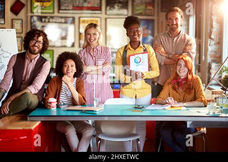 Group of young creative employees are posing for a photo while working in a pleasant atmosphere in the office together Stock Photo