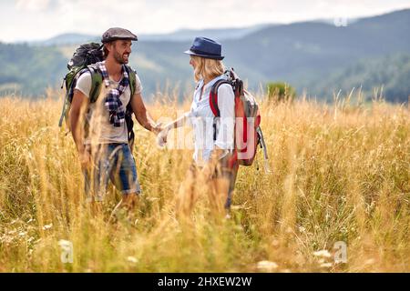 Happy couple is hiking in mountain.Joyful couple  at meadow on sunny summer day Stock Photo