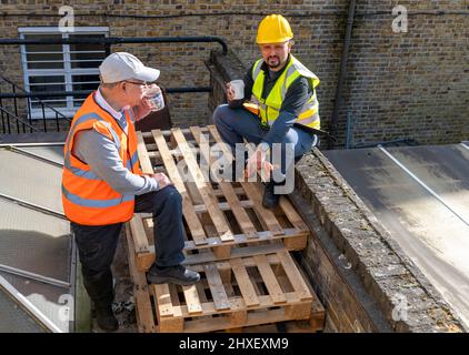 Construction workers taking a tea break on site. Stock Photo