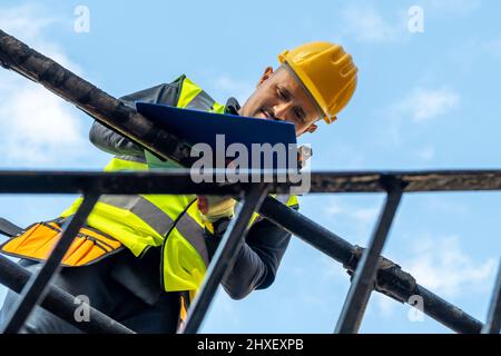 A building foreman taking notes and inspecting the construction work in site. Stock Photo