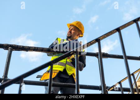 A building foreman taking notes and inspecting the construction work in site. Stock Photo