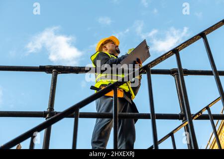 A building foreman taking notes and inspecting the construction work in site. Stock Photo