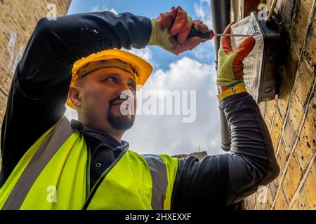 A construction worker fitting outdoor lighting. Stock Photo