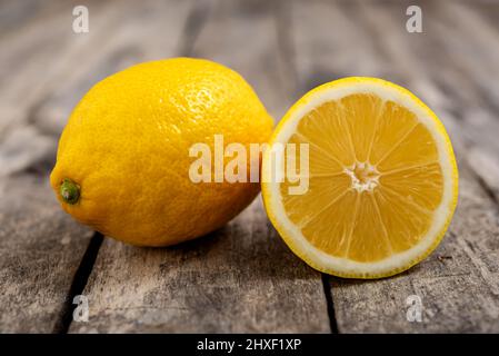 Fresh lemon cut in half on rustic wooden table. Stock Photo