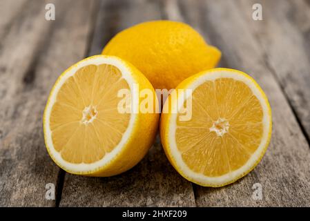 Fresh lemon cut in half on rustic wooden table. Stock Photo