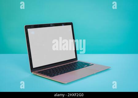 Laptop computer with blank screen on Aztec green paper background. Stock Photo