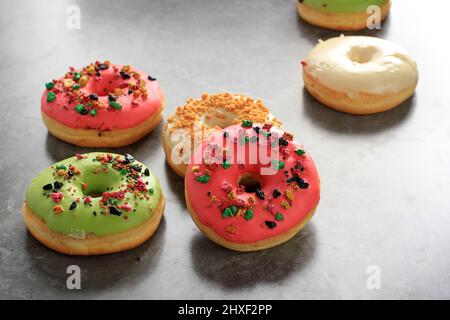 Assorted  Doughnut with Colorful Sprinkle Isolated on White Background, Copy Space for Text on Grey Cement Background Stock Photo